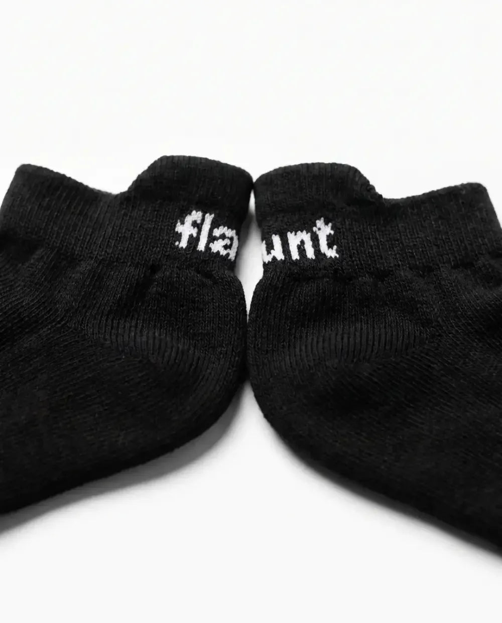 Flaunt Socks pair, flat lay, flaunt wordmark on cuff