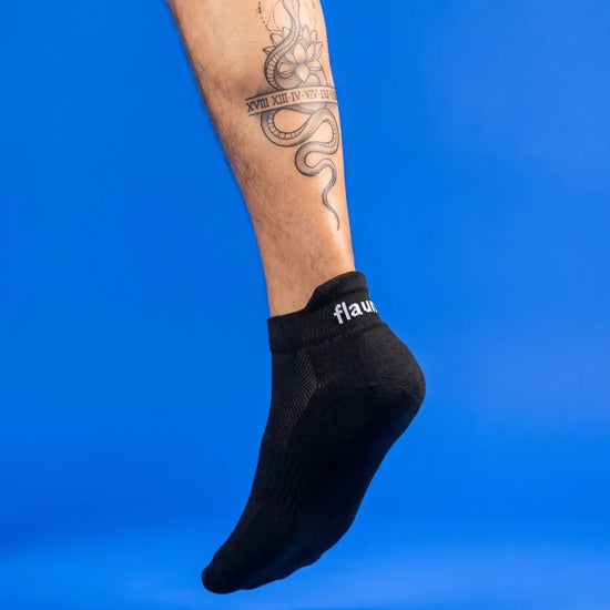 Flaunt Socks worn, foot hanging, blue background