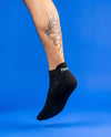 Flaunt Socks worn, foot hanging, blue background
